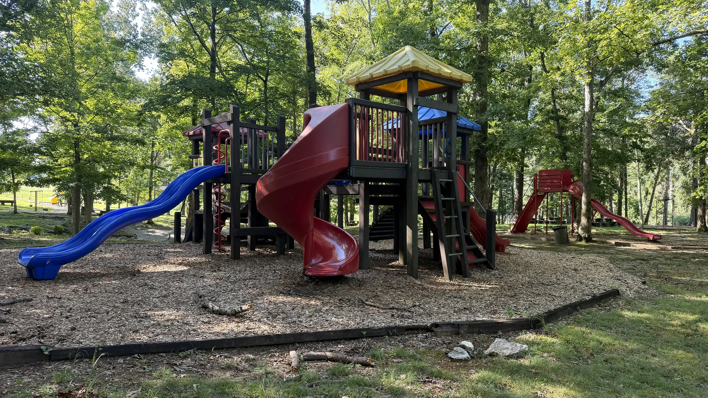 Wooded community playground with several slides at Woodson Bend