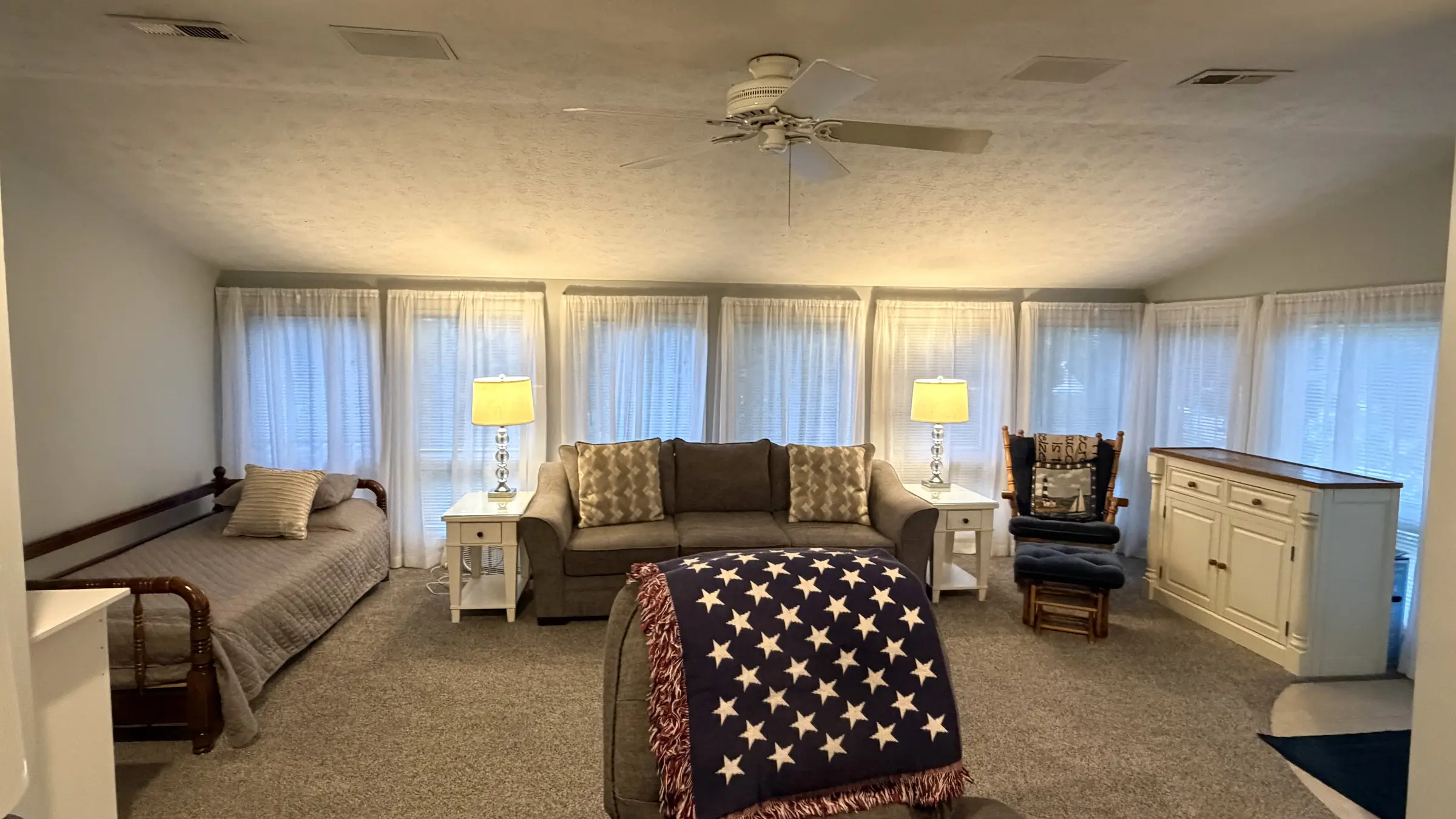 Window-lined living area with a daybed, sofa and recliner